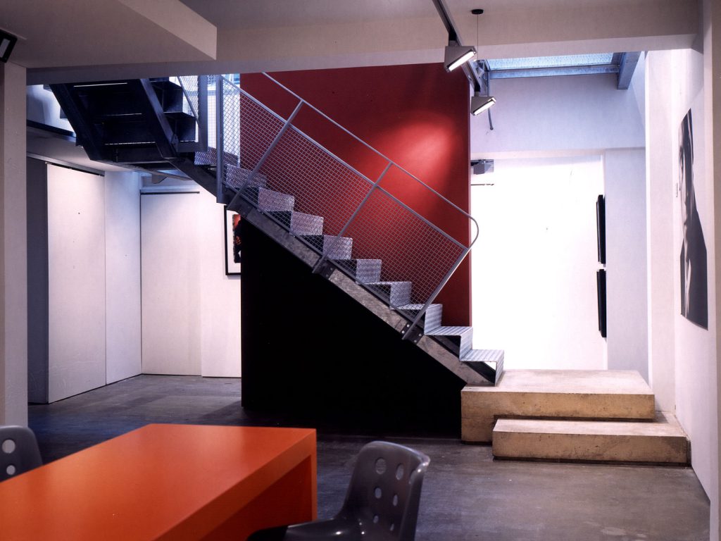 The design and construction of a new photographic gallery in the heart of London's Soho. Set in a listed building, the works include the insertion of a new glass and steel bridge and staircase opening up the existing basement. Polished concrete and high gloss resin floor finishes contrast with the neutral walls. Purpose made concrete and painted furniture adds colour and texture.